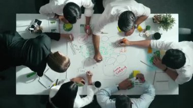 Yetenekli iş adamlarının zihin haritası kullanarak beyin fırtınası yapmak için birlikte çalışmaları zaman aşımı. Yetenekli yöneticinin sürdürülebilir enerji hakkında konuşup tartışmasının havadan görüntüsü. Hizalama.