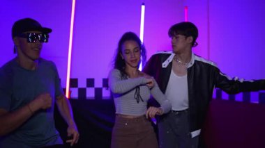 Çok kültürlü break dans takımı mor neon ışıkla stüdyoda müzik yapıyor. Stüdyoda farklı arkadaşlara bakarken serbest dans eden enerjik sokak dansçıları grubu. Çılgınca. Mutluluk.