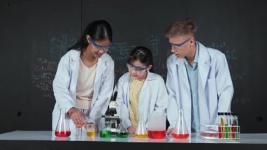 Zeki kız deney yapmak için heyecanlanan çeşitli öğrenciler iken beher kabına renkli solüsyon döker. Profesyonel bilim adamı kimyasal teoriyle kara tahtada deney yapmaya hazırlanıyor. Öğretim