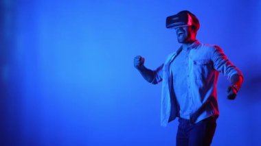 Oyun sahnesini temizlemek ya da maçı kazanmak için VR gözlükleri ve günlük kıyafetleriyle kutlama yapan çekici bir oyuncu. Akıllı iş adamı başarılı projeyi ya da satışları artırmayı kutluyor. Teknoloji. Aygıt.