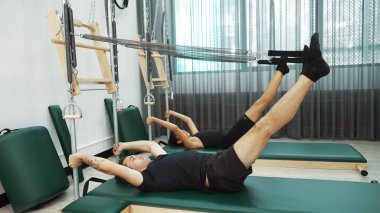 Bir grup müşteri, çekirdek dayanıklılığını ve bacak bağını geliştirmek için Cadillac reformatör makinesinde pilates egzersizleri yapıyor. Sağlıklı müşterilerin daha düşük poz verip kaldırma pozlarının üst görüntüsü. Sağlıklılık. Alışkanlık.