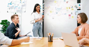 Genç ve güzel lider pazarlama stratejisini sunarken, uzman yatırımcı ve proje yöneticisi de yeni başlayan iş toplantısında iş performansını analiz etmeye çalışıyor. Çok ırklı bir grup. Tertemiz..