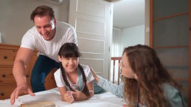 Mutlu modern aile hafta sonları küçük kızlarını neşeli bir şekilde uyandırır. Küçük kızlarına olan sevgilerini ve sevgilerini ifade ederler. Birlikte güler ve gülümserler. Titiz