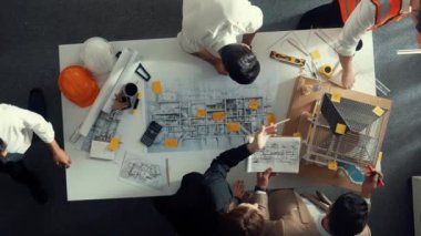 Becerikli mühendis ekibinin ev inşaatından bahsedişinin en alt görüntüsü. Mimar ya da tasarımcı grubunun planlar hakkında beyin fırtınası yapmak için tartışan ve yazan hava görüşü. Hizalama.