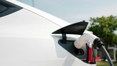 Green City Park 'taki otoparkta yavaş çekim EV elektrikli araba şarj bataryası. Sürdürülebilir ve çevre dostu şehir yolculuğu için yenilenebilir otomobil için alternatif temiz enerji teknolojisi. Yararlı
