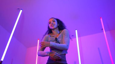 Latin dansçıların kameraya bakıp şehrin pop müziğiyle dans ettiği düşük açılı kamera. Profesyonel çekici hipster, mor veya neon ışıklı hip hop şarkısına geçiyor. Şık bir kumaş. Mutluluk.