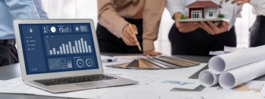 İç mimar tasarımcı grubu, daha kesin tasarım için planlar ve dizüstü bilgisayar ekran mimari yazılımı üzerinde birlikte tartışıyorlar. Modern ev tasarımı ve yenileme. İçgörü