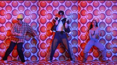 Parti sahnesinde kameraya bakarken balon geçmişiyle birlikte dans eden mutlu çok kültürlü dansçılar. Zeki hipster grubu müzik yapıyor ve sokak dansı yapıyor. Tam vücut. Mutluluk.