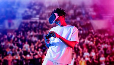 Yetişkinlerin elinde joystickle VR gözlükleri varken stadyumda arka planda bulanık oyunlar oynamaktan zevk alıyorlar. Afrikalı adam kontrol etmeyi ve artırılmış gerçeklik teknolojisini kullanmayı seviyor. Yaratıcılık.