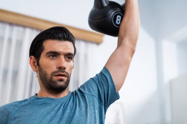 Atletik vücut ve aktif sporcu, sağlıklı vücut çalışma yaşam biçimi konsepti olarak eğlence evinde kas kazancı için kettlebell ağırlığını kaldırıyor..