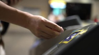 Çok kültürlü yolcuların elleri turnikelerden geçerken gökyüzü treni, metro ya da insanlarla çevrili tüp gibi toplu taşıma araçlarını kullanarak madeni paraları tarar. Çalışma rutini. Sevinçli..