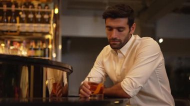 Beyaz tişörtlü, kokteyl içen zeki bir adam. Eski moda parti içkisi. Arkadaşlarını ya da çiftlerini cuma gecesi kulüpte bekleyen lüks bir tezgah barda bekliyor. Vinosity.