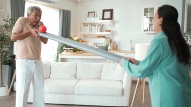 Yaşlı bir adam evde partneriyle top yuvarlama oyunu oynuyor, zihinsel ve fiziksel sağIık için el-göz koordinasyonu, odaklanma ve motor becerileri pratiği yapıyor. Sağlık hizmetleri konseptini engelliyor. Myrmidon.