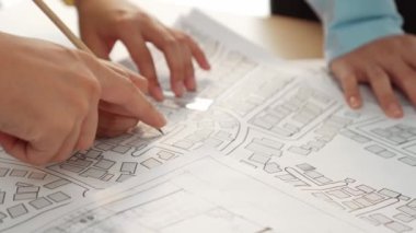 Mimari ekipmanlarla toplantı masasında ev tasarımı üzerine profesyonel mühendis ekibi tartışması ve modern ofiste bina planı dağılımı. Eline odaklan. - Yakın çekim. Tanımlama.