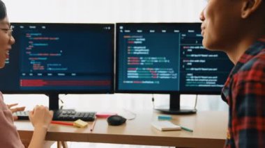 Yavaş çekim arkası yazılım geliştirici mühendisi bilgisayar programlama için birlikte çalışarak hata ayıklama kodunu çözüyor, ofiste monitörde karmaşık algoritmaları çözüyor. Filizlenen