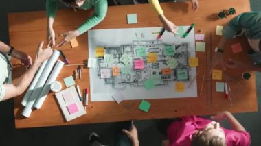 Zeki iş adamlarının el sıkışması ve kontrat yapmaları. Birlikte çalışan mimar mühendisinin hava görüşü ve planlar ve notlarla masada proje veya plan yapmak. Sempozyum.