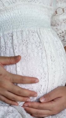 Hamile bir kadın çocuğuna bakarken kendini mutlu hissediyor. Hamile karnında bebek taşıyan hamile bir anne. Doğum öncesi bakım ve kadın hamileliği konsepti.