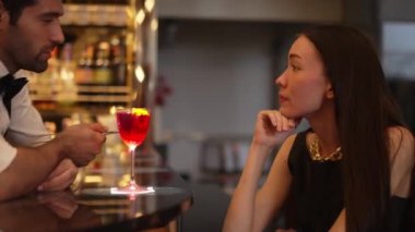 Barmen lüks tezgah barında güzel misafirler için çiçeklerle süslenmiş karışık votka kokteyli servis ediyor. Mükemmel canlı renk sunumu. Atmosfer gece kulübünü ön plana çıkarıyor. Vinosity.