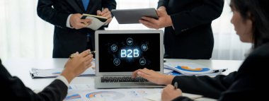 İş adamı B2B peyzajında geziniyor, iş-iş bağlantılarını geliştirmek için kullanım teknolojisi kullanıyor. B2B etkileşimini yeniden şekillendiren keşifler, iş-iş stratejilerinde yenilikleri yönlendiren araçlar. canlı