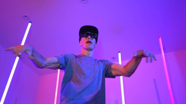 Beyaz dansçının gösterişli gözlükler taktığı ve break dans yaptığı alçak açılı kamera. Çekici adam kendinden emin bir şekilde kameraya bakarken enerjik bir performans ve hareket gösterdi. Mutluluk.