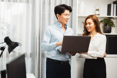 Gülümseyen Asyalı iş arkadaşları modern ofiste dizüstü bilgisayar pazarlama projesi hakkında konuşurken. Yeni sosyal medya kanalında başarılı müşteri ihtiyaçları analiz ediliyor. İnfobahn.