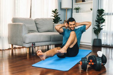 Atletik ve sporcu adam, evde vücut egzersizi yaparken spor ve spor yaşam tarzına uyum sağlamak için spor minderinde çatırdıyor. Gaiety ev egzersizi antrenman konsepti.