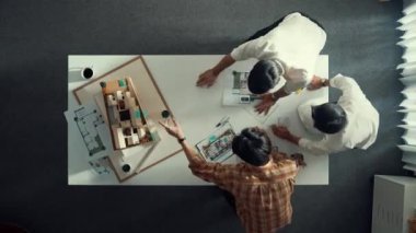 Tasarımcının modelini incelerken inşaat hakkında tartışması zaman aşımı. Toplantı masasında konuşurken ve yazarken fikri açıklayan mimar mühendisinin üst görüşü. Hizalama.