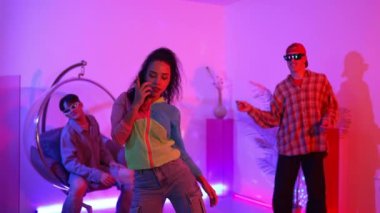 İspanyol hipster renkli kıyafetler giyer ve serbest stil müziğe el sallar. Profesyonel break dansçı neon ışıklarıyla ve modern stüdyo arkadaşlarıyla coşkuyla dans ediyor. Mutluluk.