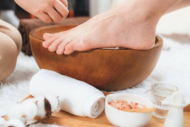 Kadınlar lüks spa salonlarında keyifli ayak masajlarına devam ederken, masör de hafif gün ışığı atmosferinde refleksoloji terapisi veya otel ayak spa 'sında. Sessiz.