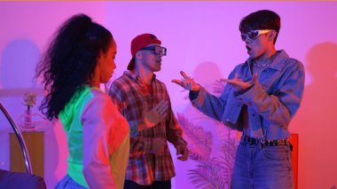 İspanyol hipster renkli kıyafetler giyer ve serbest stil müziğe el sallar. Profesyonel break dansçı neon ışıklarıyla ve modern stüdyo arkadaşlarıyla coşkuyla dans ediyor. Mutluluk.