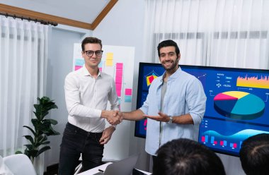 Analist ekip lideri, iş zekası ya da BI gösterge paneli ile FIntech yazılım gücünü kullanarak başarılı veri analizi toplantısından sonra iş arkadaşıyla tokalaştı. Tedbirli