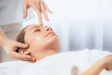 Kafkasyalı kadın stres önleyici kafa masajından ve lüks tatil beldesi ya da otel spa salonundaki modern ışık ortamında yüz güzelliği eğlencelerini şımartmaktan hoşlanıyor. Sessiz.