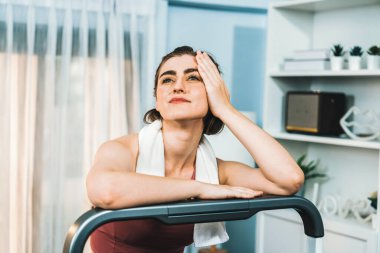 Spor ve atletik bir kadın, evdeki fiziğe ve sağlıklı spor yaşam tarzına uygun vücut egzersizi sırasında koşu bandında koşuyor. Gaiety evde egzersiz eğitimi.