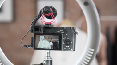 Arka görünüm, kamera ekranında kadın nüfuzunu gizler. Video görüntüleme, video görüntüleme, giysi, sosyal medya ya da blog. Canlı yayın için canlı stüdyo ışıklandırması olan kız canlı yayın pazarlama kaydı