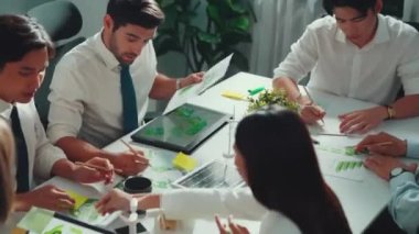 Profesyonel akıllı iş adamları, temiz enerji ve sürdürülebilir yatırımı rüzgar değirmeniyle toplantı masasında kullanma, çevre grafiği ve ahşap ev modeli ile belgelendirme konusunda tartışıyorlar. Hizalama.