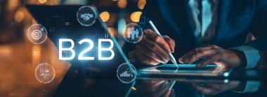 İş adamı B2B peyzajında geziniyor, iş-iş bağlantılarını geliştirmek için kullanım teknolojisi kullanıyor. B2B etkileşimlerini yeniden şekillendirir, iş stratejilerindeki yenilikleri tetikler. EIDE