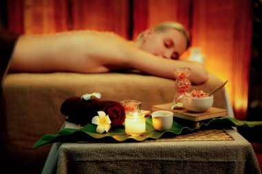 Aromaterapi masajı ambiyansı ya da spa salonu kompozisyon düzeneği bulanık kadınlara odaklı dekor mumları ve spa aksesuarları ile tatil köyü veya otel arka planında keyifli aroma spa masajı yapan. Sessiz.