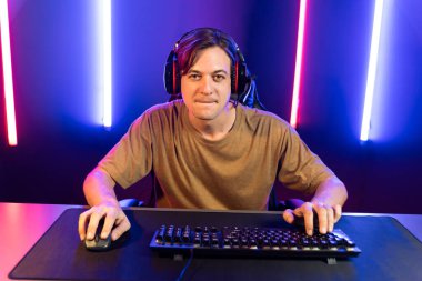 Kazanmak için çevrimiçi oyun oynayan akıllı flama makinesinin sunucu kanalı, neon ışıklı odada seçilen takım yarışması için izleyicilerle birlikte canlı yayında canlı yayında kulaklık takıyor. Bireysel.