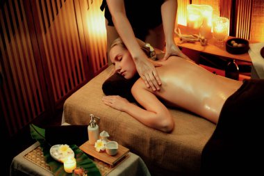 Beyaz kadın müşteri stres önleyici spa masajının keyfini çıkarıyor ve lüks otel ya da otelde sıcak mum ışığında güzellik teniyle eğleniyor. Sessiz.