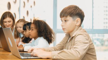 Çocuk BTMM Teknoloji sınıfında çok kültürlü bir arkadaşla bilgisayar oyunu oynuyor. Mühendislik kodları ve bulanık geçmişi olan programlama sistemi üzerine çok kültürlü bir öğrenci çalışması. Etkinlik.