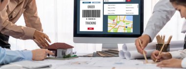 İç mimar tasarımcı grubu, daha kesin tasarım için planlar ve dizüstü bilgisayar ekran mimari yazılımı üzerinde birlikte tartışıyorlar. Modern ev tasarımı ve yenileme. İçgörü