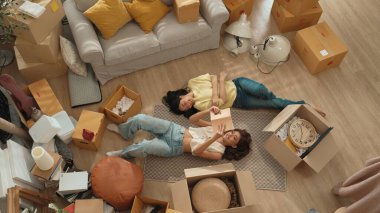 Genç bayan işyeri sahibi dükkanda dikilirken elinde karton tutuyordu. Teslimat ya da nakliye işlemleri için hazırlık yaparken paket ve kutu taşıyan çekici, mutlu girişimci. Myrmidon.