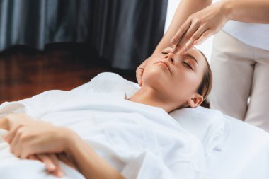 Kafkasyalı kadın stres önleyici kafa masajından ve lüks tatil beldesi ya da otel spa salonundaki modern ışık ortamında yüz güzelliği eğlencelerini şımartmaktan hoşlanıyor. Sessiz.