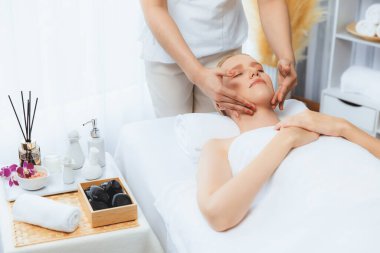 Kafkasyalı kadın stres önleyici kafa masajından ve lüks tatil beldesi ya da otel spa salonundaki modern ışık ortamında yüz güzelliği eğlencelerini şımartmaktan hoşlanıyor. Sessiz.