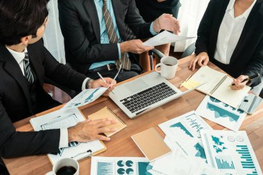 Ofis masasındaki finansal veri raporlarını analiz eden çeşitli bir grup iş analisti. Stratejik pazarlama planlaması için iş istihbarat analizine göre grafikler ve grafikler.