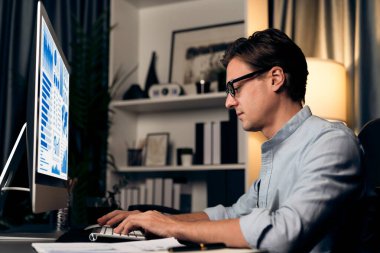 Akıllı iş adamı iş paragrafı dinamik pazarlama analizi planını analiz ediyor. Kağıt kağıtları ve bilgisayar monitörü raporlarını gece evdeki belge verileriyle karşılaştırmak için hazırlıyor. Bireysel.