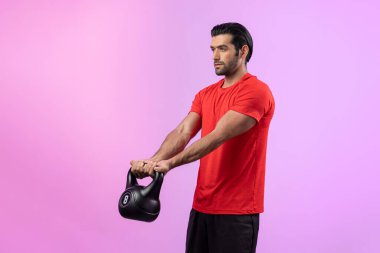 Vücut geliştirme egzersizi için ağırlık kaldırmak için kettlebell kullanan atletik ve sportif bir adam izole edilmiş arka planda ayakta duruyor. Sağlıklı aktif ve vücut bakımı yaşam tarzı