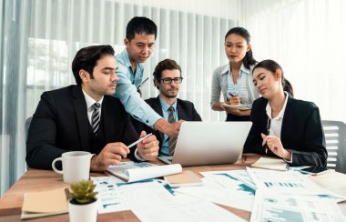 Ofis masasındaki finansal veri raporlarını analiz eden çeşitli bir grup iş analisti. Stratejik pazarlama planlaması için iş istihbarat analizine göre grafikler ve grafikler.