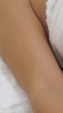 Lüks bir spa merkezinde masaj terapisti tarafından yüz masajı ve spa tedavisi için kaplıcaya uzanmış rahat bir kadın. Sağlık, stres atma ve gençleştirme kavramı.