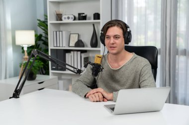 Sunucu kanalı, gülümseyen akıllı yayıncı kaydı, senaryosu ve akıllı telefonuyla sosyal medyada sohbet programı, kulaklık takarak modern ev stüdyosundaki video flamalarını kaydediyor. Bireysel.